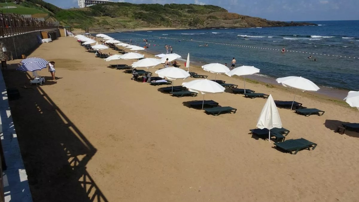Altınkum sahilinde beyaz şemsiyeler ve deniz manzarası